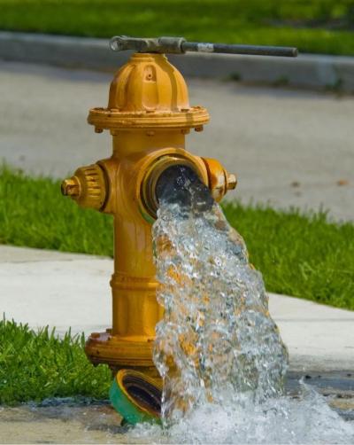 Yellow Fire Hydrant pouring water.